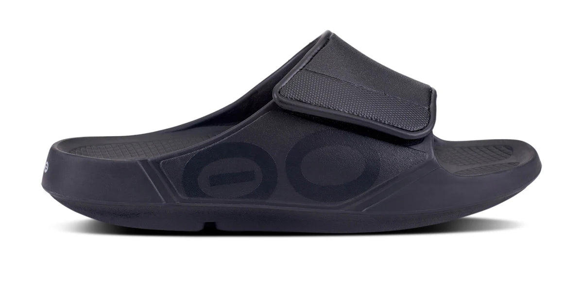 OOFOS Sport Flex slide in matte black, lateral profile with the strap fastened