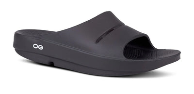 OOFOS OOahh Slide 1100 in black, angled view showing the cupped heel and OOfoam strap