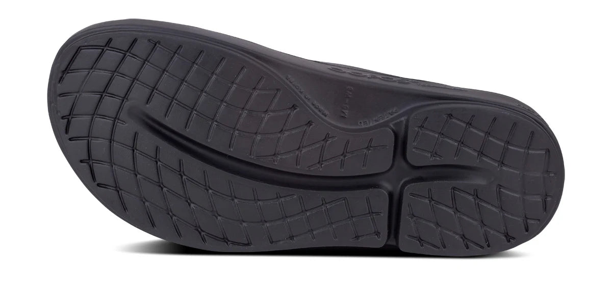 OOFOS OOahh Slide 1100 in black, outsole tread pattern
